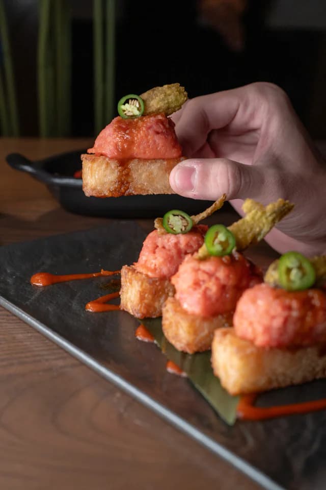 Spicy tuna crispy rice bites on a slate board