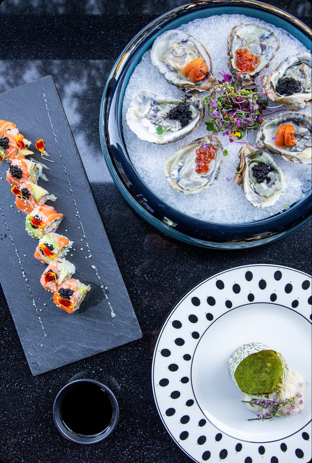 Sushi topped with caviar on a dark plate at Tomo Japanese