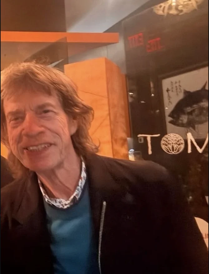Mick Jagger at Tomo Japanese in July 2026, the restaurant wordmark on the wall behind him